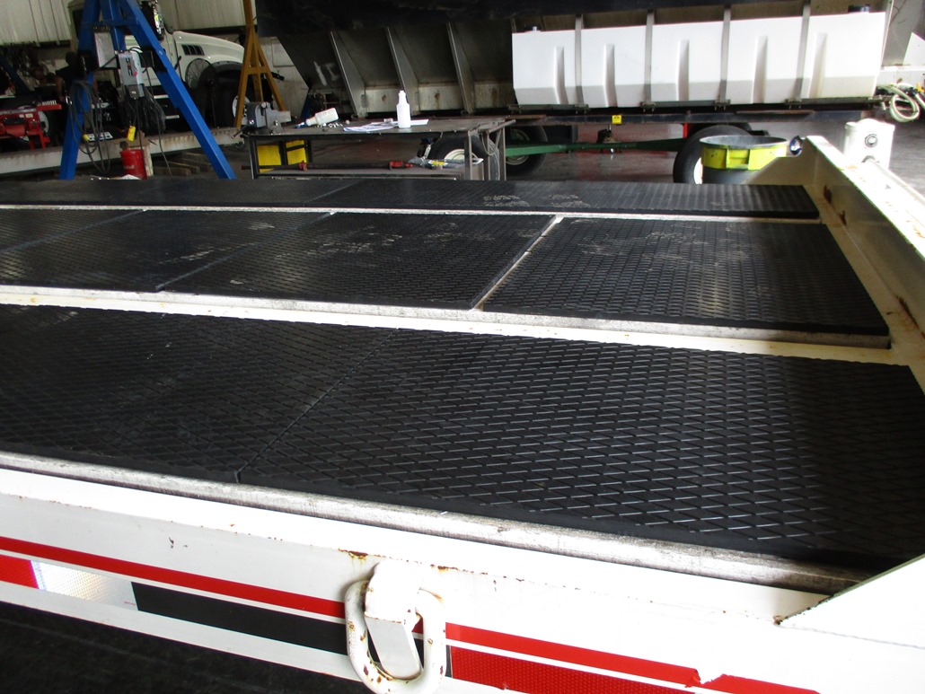 Black textured decking panels installed on a trailer, shown close up